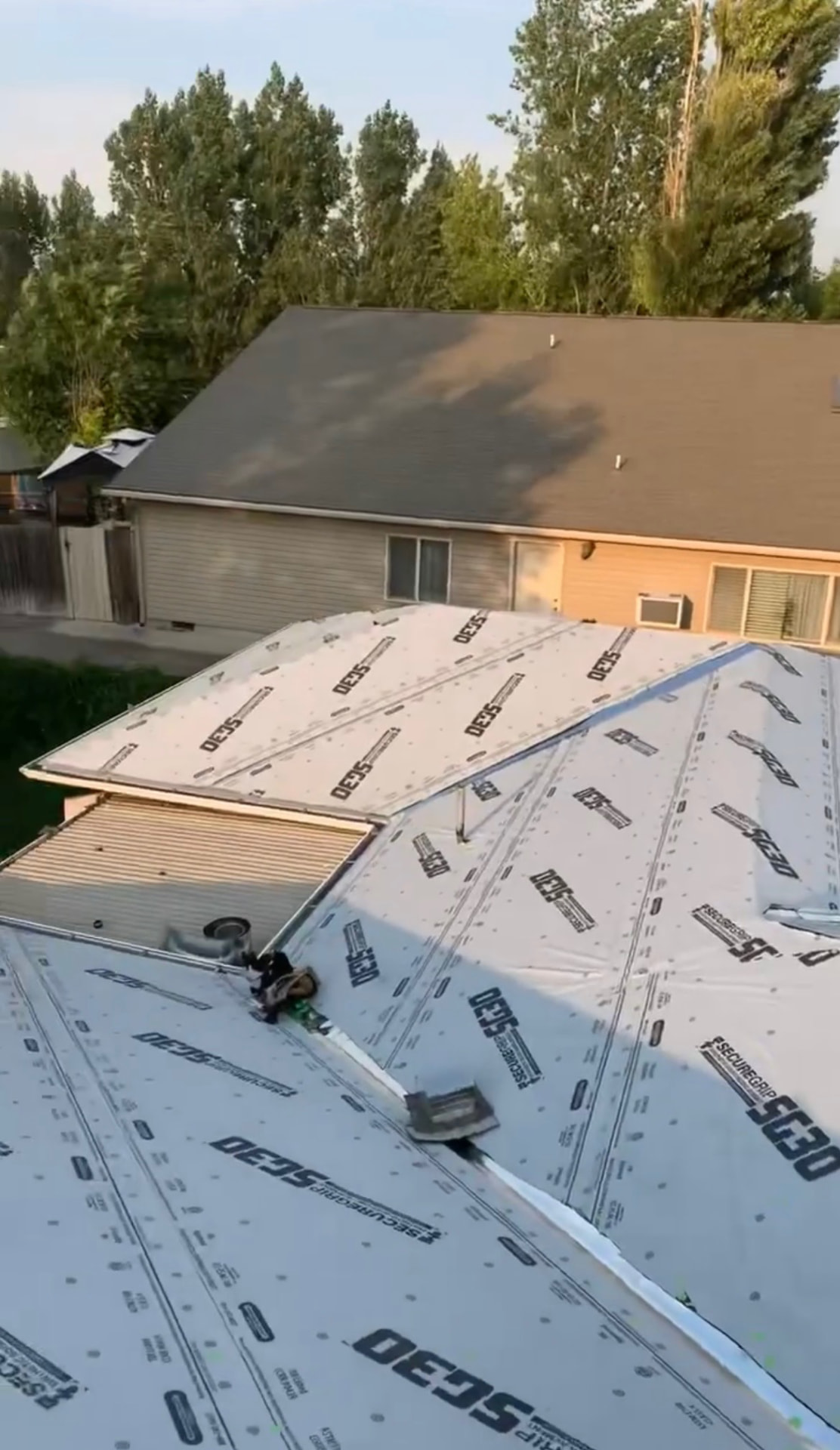 Roof replacement in progress with new synthetic underlayment installed